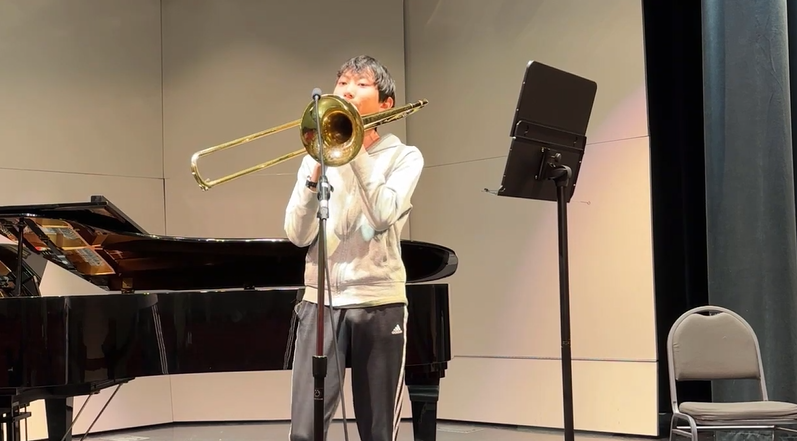 asian male playing trombone